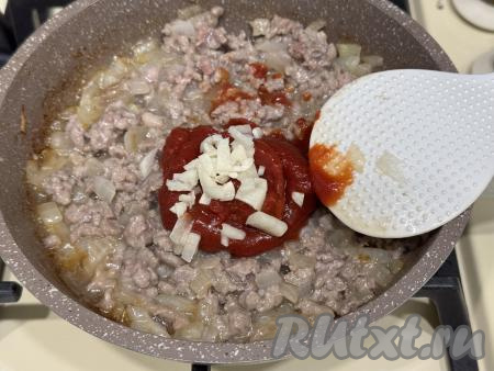 Обжарить фарш с луком, часто перемешивая и разбивая комочки мяса, в течение 12-15 минут. Затем добавить в сковороду томатную пасту и достаточно мелко нарезанный (или пропущенный через пресс) чеснок, тщательно перемешать.