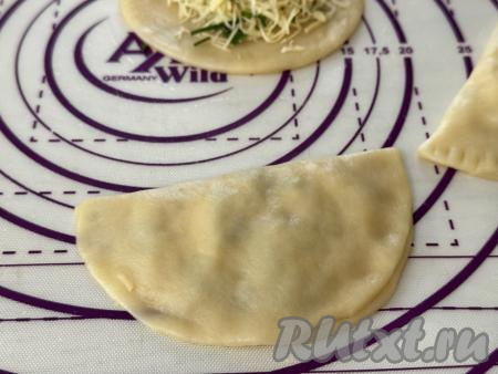 Частью круга без начинки накрыть сторону круга с начинкой, пряча начинку внутрь и формируя чебурек.&nbsp;&nbsp;