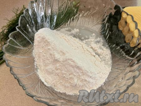 Прежде всего нужно замесить тесто для чебуреков, для этого в объёмную миску нужно всыпать 350 грамм муки, добавить соль, влить воду комнатной температуры.