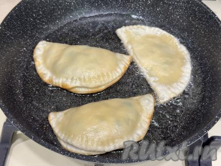 В сковороду влить растительное масло, разогреть, затем выложить несколько чебуреков с начинкой из сыра и зелени.&nbsp;