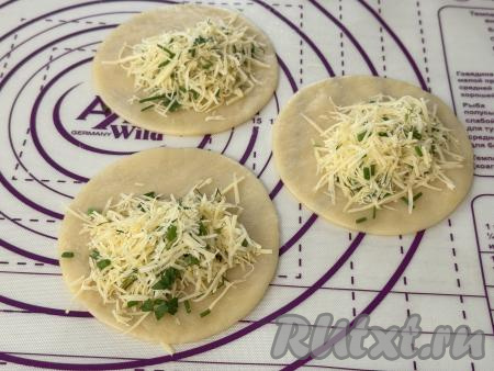 Начинку зрительно разделить на 8-10 частей (по количеству вырезанных кружочков). На одну половину кружка, немного отступая от края, выложить часть начинки из сыра и зелени.