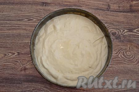 Дно разъёмной формы для выпечки (у меня форма диаметром 23 сантиметра) застелить пергаментом. Смазать бока и пергамент небольшим количеством растительного масла (благодаря маслу, готовая шарлотка будет лучше выниматься из формы). Выложить тесто в форму.