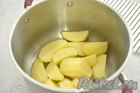 Слоёное дрожжевое тесто размораживаем при комнатной температуре. Картошку очищаем, нарезаем на крупные кусочки, выкладываем в кастрюлю, заливаем полностью холодной водой, по вкусу солим, ставим на огонь. После закипания варим картошку до готовности (минут 20-25, готовые картошины должны легко прокалываться ножом). Сливаем всю воду, в которой варился картофель.