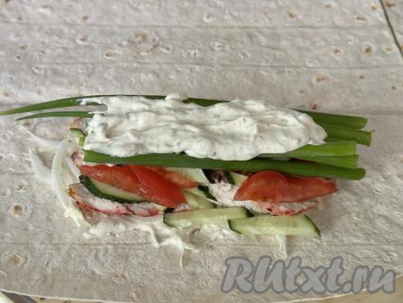 Затем выложить часть зелёного лука и сверху смазать 1 столовой ложкой соуса.