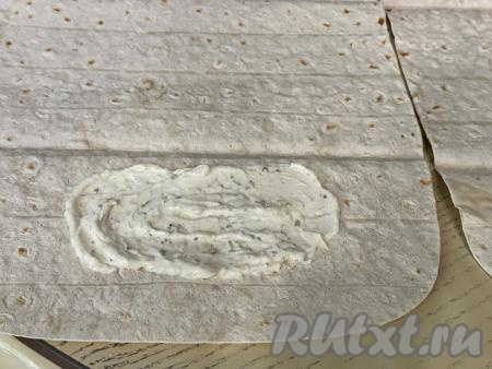 Теперь можно приступать непосредственно к формированию шаурмы. Из предложенного количества ингредиентов мы будем формировать 4 шаурмы. Взять 1 лист лаваша. Ближе к одному краю лаваша, отступая от краёв лаваша, выложить 1 столовую ложку соуса, немного его разровнять.