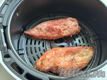 Выложить куриное филе на решётку аэрогриля, запекать под закрытой крышкой при температуре 180 градусов 25 минут (до готовности мяса). Для того чтобы проверить готовность мяса, нужно разрезать филе пополам. Если разрез будет без розовых вкраплений, значит мясо готово.