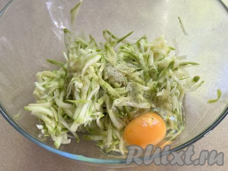 По прошествии 5-10 минут отжать кабачок от выделившегося сока (можно просто частями брать кабачковую массу в руку и, сжимая в ладони, отжимать выделившийся сок). Кабачковую массу, отжатую от лишнего сока, выкладывать в объёмную миску. Сок, который выделился из кабачков в процессе отжимания, нам не понадобится. В миску с отжатой кабачковой массой добавить яйцо.