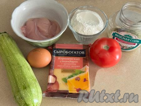 Подготовить продукты для приготовления пиццы из кабачков с курицей в духовке. Куриное филе промыть водой и обсушить. Если у кабачка тонкая кожура, её можно не срезать, достаточно будет вымыть овощ и обрезать кончики с двух сторон. Если кожура у кабачка твердоватая, тогда её нужно срезать. Если у кабачка крупные семечки, их нужно будет удалить. Для приготовления пиццы потребуется 330 грамм подготовленного кабачка. Помидор вымыть.