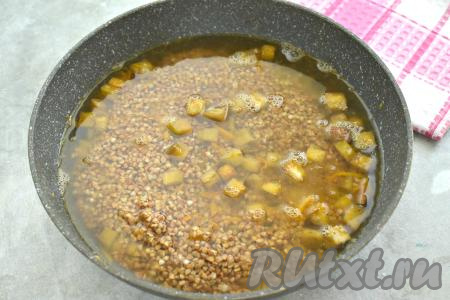 Вливаем в сковороду 400 миллилитров кипящей воды, доводим до кипения и уменьшаем огонь. Гречку и воду я отмеряю одним и тем же стаканом объёмом 200 миллилитров, то есть для приготовления 1 стакана гречневой крупы я вливаю 2 стакана воды.