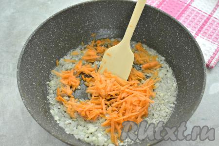 К обжаренному луку выкладываем натёртую на крупной тёрке морковку, перемешиваем овощи и обжариваем их минут 5 (морковка должна стать мягкой), иногда помешивая.