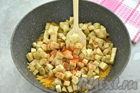 После того как морковка обжарится до мягкости, добавляем в сковороду нарезанный баклажан и натёртый на мелкой тёрке (или пропущенный через пресс чеснок), приправляем специями (у меня - чёрный молотый перец и паприка), перемешиваем.