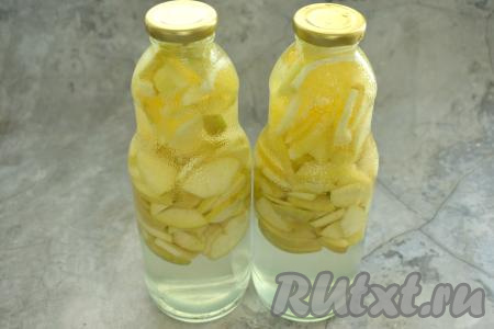 Кипятим воду. Банки с яблоками и апельсинами до самого верха заполняем кипящей водой, прикрываем прокипячёнными крышками и оставляем на 15 минут.