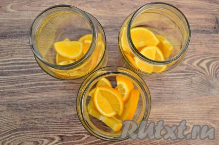 Вскипятить примерно 2,4 литра воды. По простерилизованным банкам равномерно распределить нарезанные апельсины.