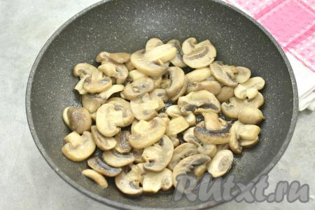 В сковороде разогреваем растительное масло, выкладываем нарезанные шампиньоны. На среднем огне обжариваем грибы 5 минут, периодически перемешивая (до выпаривания жидкости).