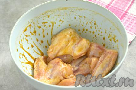 Подготовленные куриные крылышки выкладываем в миску с горчично-медовым соусом, перемешиваем, покрывая крылья мёдом и горчицей со всех сторон. Миску с крылышками, покрытыми соусом, затягиваем пищевой плёнкой (или накрываем крышкой) и отправляем в холодильник мариноваться минимум на 30 минут.