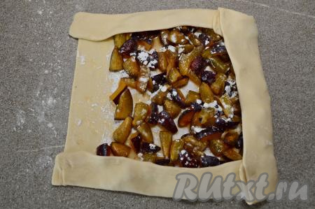 Подогнуть две короткие стороны теста на начинку. Свернуть тесто в плотный рулет, начиная с любой неподвёрнутой стороны.