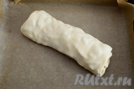 Выложить штрудель швом вниз на противень, заранее застеленный пергаментом.