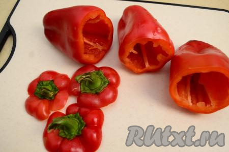 Срезать у перцев острым ножом верхушку вместе с чашелистиком. Удалить из болгарских перцев перегородки и промыть их внутри проточной водой, чтобы избавиться от семечек. Стряхнуть с перцев воду, которая осталась после промывания овощей. Верхушки я отдельно отделяю от чашелистиков и тоже замораживаю, складывая все вместе в отдельный пакет. Зимой добавляю их в супы-пюре.