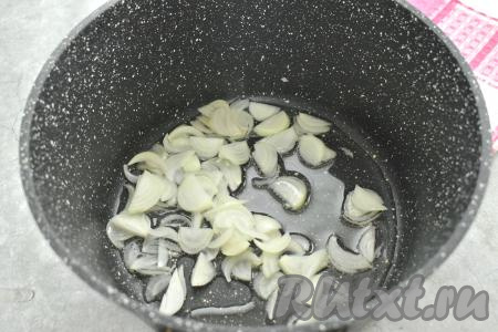 Очищаем лук, чеснок и морковь. В кастрюле с толстым дном (или в достаточно глубокой сковороде) прогреваем растительное масло, выкладываем лук, нарезанный на четверть кольца (или полукольца), обжариваем на среднем огне, иногда помешивая, в течение 3-4 минут (до прозрачности лука).
