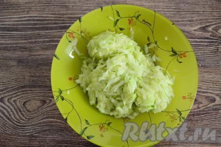 Пока замешивалось тесто, из натёртого кабачка выделился сок. Сок, выделившийся из кабачка, нужно тщательно отжать. Для того чтобы отжать сок, я частями беру кабачковую массу в руку и тщательно сжимаю в ладони, отжимая сок. Кабачковую массу, отжатую от сока, выложить в глубокую тарелку. Выделившийся сок нам не понадобится. Вес отжатого от сока кабачка у меня составил 300 грамм.