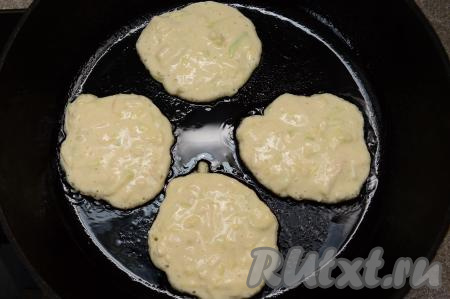Влить немного растительного масла в сковороду, хорошо его разогреть, затем уменьшить огонь до среднего. Выкладывать в сковороду по 1 столовой ложке кабачково-яблочного теста в виде круглых оладий.
