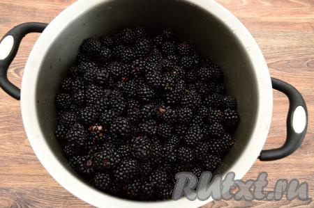 Ежевику перебрать, удаляя порченные ягоды. Для приготовления варенья я использовала 2 килограмма перебранной ежевики. Промыть ежевику под проточной водой, лишней воде дать стечь, сложить в глубокую кастрюлю с толстым дном. Я мою ежевику частями, для этого аккуратно выкладываю часть ягод в дуршлаг, затем промываю водой, лишней воде даю стечь. 