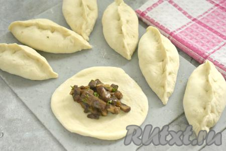 В центр каждой лепёшки из теста выкладываем по 1 полной столовой ложке остывшей грибной начинки. Лепим пирожки, соединяя края каждой лепёшки над начинкой.