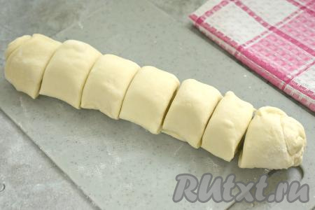Разморозившееся слоёное тесто&nbsp;выкладываем на поверхность, припылённую мукой. Не раскатывая, сворачиваем пласт теста в плотный рулет. Получившийся рулет разрезаем на 7 равных частей.
