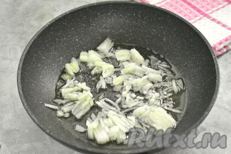 Разогреваем в сковороде растительное масло, выкладываем мелко нарезанный лук и обжариваем его на среднем огне до мягкости (минуты 3-4), иногда помешивая.