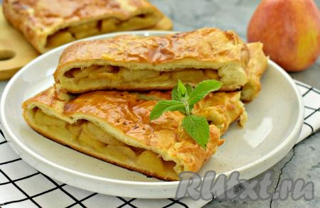 Противень с готовой выпечкой достаём из духовки. Даём в меру сладкому, ароматному пирогу немного остыть, а затем нарезаем его на кусочки и подаём к столу. Сочетание нежного слоёного дрожжевого теста и мягкой, сочной яблочной начинки делает этот пирог особенно вкусным.