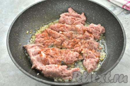 К обжаренному луку добавляем мясной фарш. По вкусу его солим, приправляем специями (у меня - чёрный молотый перец и паприка). Мясной фарш можно взять как покупной, так и приготовленный в домашних условиях. Я приготовила смешанный фарш, пропустив через мясорубку кусочки свинины и говядины, но можно сделать фарш из любого мяса (например, из курицы, индейки, только из свинины или только из говядины).