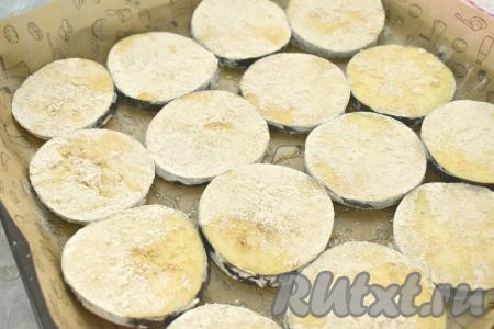 Застилаем противень пергаментом. Смазываем пергамент растительным маслом. Выкладываем на противень кружочки баклажана, обваленные в крахмале. Сверху баклажаны с помощью силиконовой кисточки немного смазываем растительным маслом.&nbsp;