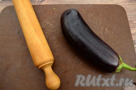 Вымыть баклажаны. Отбить каждый баклажан скалкой, чтобы он стал мягким и пластичным. Отбивать скалкой нужно со всех сторон, но не очень сильно, чтобы не разбить овощи и сохранить целостность кожуры.