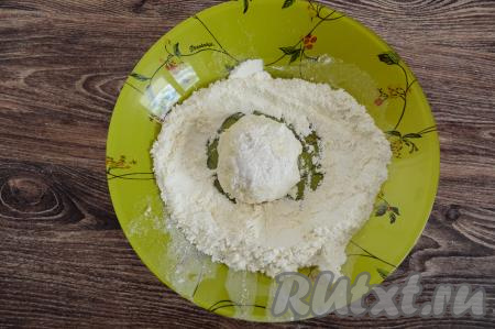 В глубокую тарелку всыпать 2 столовых ложки муки. Зрительно разделить творожно-яблочное тесто на 9 равных частей (именно столько сырников мы и будем жарить). Руками, слегка смоченными водой, из каждой части теста сформировать округлый сырник и сразу же обвалять его в муке со всех сторон. Чтобы липкое тесто не приставало к ладоням, я смачиваю руки водой перед формовкой каждого сырника.