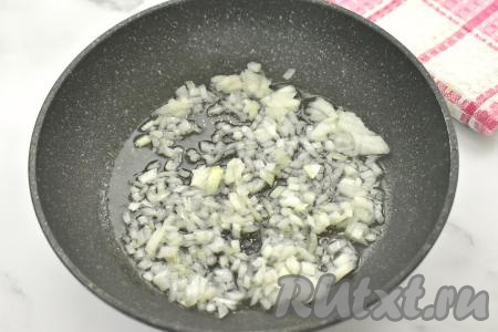 В сковороде хорошо прогреваем растительное масло, выкладываем очищенный и достаточно мелко нарезанный лук. Обжариваем лук на среднем огне, иногда помешивая, до мягкости (ориентировочно в течение 3-4 минут).