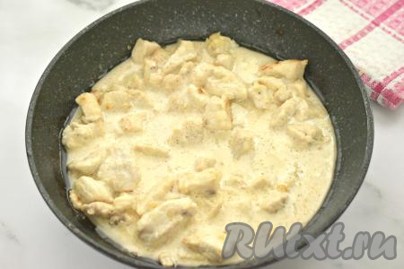 После того как мясо курицы обжарится с луком в течение 7-8 минут, вливаем в сковороду получившийся сливочный соус, перемешиваем. После закипания соуса тушим куриное филе на небольшом огне 2-3 минуты (до загустения сливок).