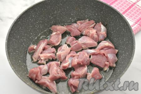 Мякоть индейки нарезаем на небольшие кусочки, солим, перемешиваем. Прогреваем растительное масло в глубокой сковороде, выкладываем кусочки индейки. Обжариваем мясо на среднем огне, иногда перемешивая, в течение 5-7 минут (до изменения цвета мяса со всех сторон).