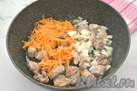 К обжаренной индейке выкладываем мелко нарезанный лук и натёртую на крупной тёрке морковку, перемешиваем мясо с овощами. Обжариваем 5-6 минут (до мягкости моркови), иногда помешивая.