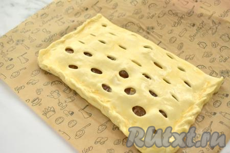 Сторону теста с вареньем накрываем стороной теста с разрезами. Плотно скрепляем края теста, формируя закрытый пирог. В небольшой ёмкости соединяем желток и молоко, взбиваем вилкой до однородности, получившейся смесью смазываем поверхность пирога.&nbsp;