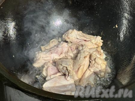 Обжарить части курицы в течение 7 минут (до изменения цвета мяса со всех сторон), периодически перемешивая.