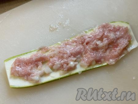 Пока веер из кабачка остывает, нужно взять второй кабачок, нарезать его на полоски толщиной 5 миллиметров (у меня получились 6 полосок). Получившиеся полоски из кабачка выложить в кастрюлю с кипящей водой, после закипания воды уменьшить огонь, варить 5 минут. Отваренные полоски из кабачка аккуратно достать из кастрюли, выложить на бумажные полотенца, чтобы стекла вода, дать остыть. На 6 остывших полосок из кабачка выложить фарш, равномерно распределяя его по всей полоске.&nbsp;