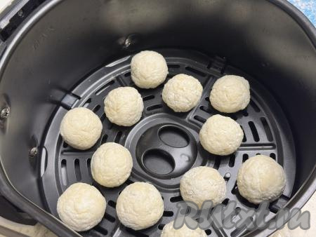 Часть творожных шариков на небольшом расстоянии друг от друга выложить в чашу аэрогриля. Шарики из творога увеличатся в размере во время выпечки.