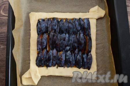 Выложить полоски слив кожурой вверх достаточно плотно на дно пирога.
