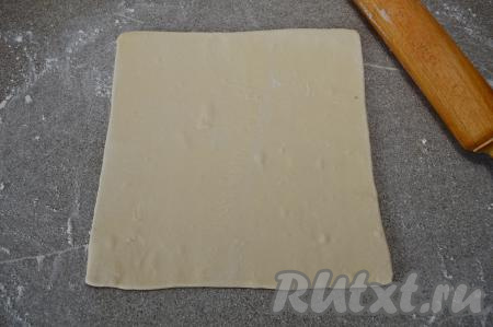 На присыпанной мукой поверхности разморозившееся слоёное бездрожжевое тесто&nbsp;раскатать скалкой&nbsp;в квадрат толщиной примерно 3 миллиметра. У меня получился квадрат со стороной 24 сантиметра.