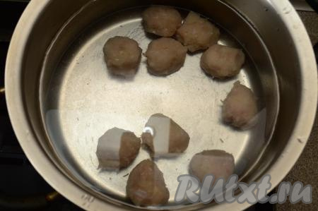 В кастрюлю влить воду, выложить фрикадельки, поставить на сильный огонь.