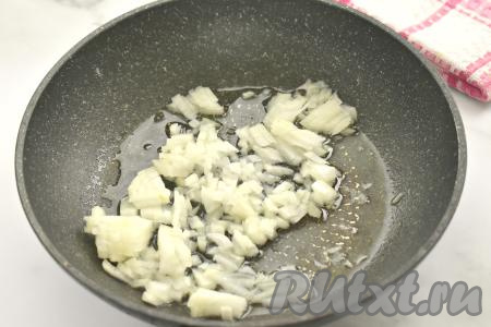 Пока варится булгур, займёмся обжариванием овощей. Лук и морковь очищаем. Моем капусту, морковку и лук. Прогреваем растительное масло в сковороде, выкладываем мелко нарезанный лук, обжариваем его на среднем огне до прозрачности (ориентировочно в течение 3-4 минут), иногда помешивая.