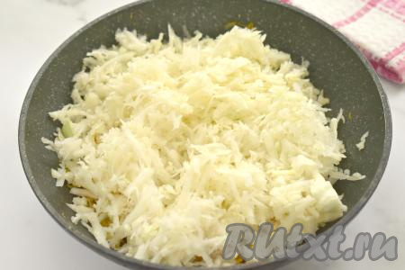 Белокочанную капусту нарезаем на мелкие кусочки (или натираем на крупной тёрке), добавляем на сковороду с обжаренными овощами, перемешиваем и обжариваем 10-15 минут (до мягкости капусты), иногда помешивая.