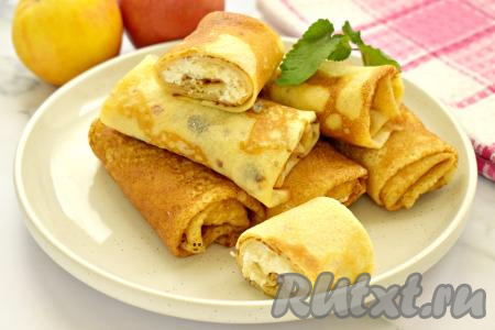 Блины с начинкой из творога и яблок можно сразу подавать к столу, дополнив, по желанию, сметаной. Мне больше нравится есть эти блинчики тёплыми, при необходимости их можно подогреть в микроволновке. В нашей семье блины с творожно-яблочной начинкой быстро исчезают со стола.