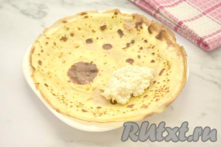 Когда пожарились все блины, можно приступать к фаршировке. На готовый блинчик кладём 1 столовую ложку начинки из творога и яблока ближе к одной стороне.&nbsp;Сворачиваем блинчик конвертиком, подворачивая три стороны блина на начинку и скручивая его в рулет, начиная со стороны с начинкой.