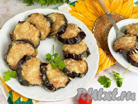 Горячие кружочки баклажана с фаршем, покрытые аппетитной корочкой из сыра, вынуть из духовки, переложить на тарелку и в горячем виде подать к столу. Блюдо получается и сытным, и вкусным, и аппетитным, а готовится просто и достаточно быстро.